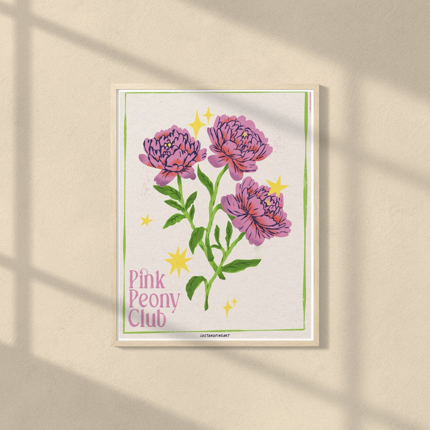 Framed artwork of pink peonies with 'Pink Peony Club' text on a beige wall.
